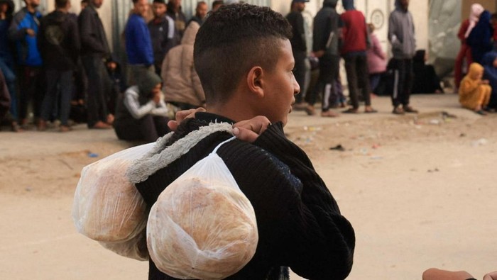 Palestinians wait to buy bread from a distribution point, amid a ceasefire between Israel and Hamas, in Khan Younis, in the southern Gaza Strip November 17, 2025. REUTERS/Haseeb Alwazeer