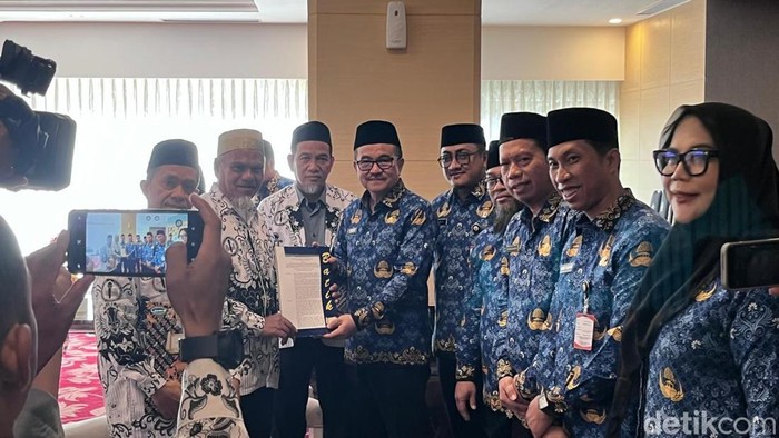 Sekda Sulsel Dr Jufri Rahman menyerahkan SK pengaktifan kembali menjadi ASN kepada dua guru SMA di Luwu Utara.