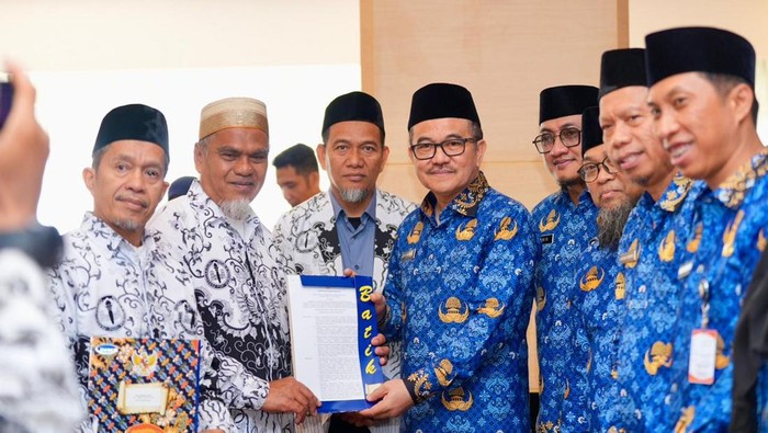 Sekda Sulsel Dr Jufri Rahman menyerahkan SK pengaktifan kembali menjadi ASN kepada dua guru SMA di Luwu Utara.