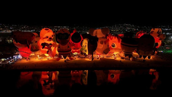 Warna-warni balon udara kembali menghiasi langit León, Guanajuato, Meksiko, saat Festival Balon Udara Internasional 2025 berlangsung meriah pada Minggu (16/11). Dari udara, pemandangan balon raksasa yang memantul di atas permukaan danau tampak seperti lukisan hidup, memikat ribuan pengunjung yang memenuhi kawasan festival sejak pagi. REUTERS/Henry Romero