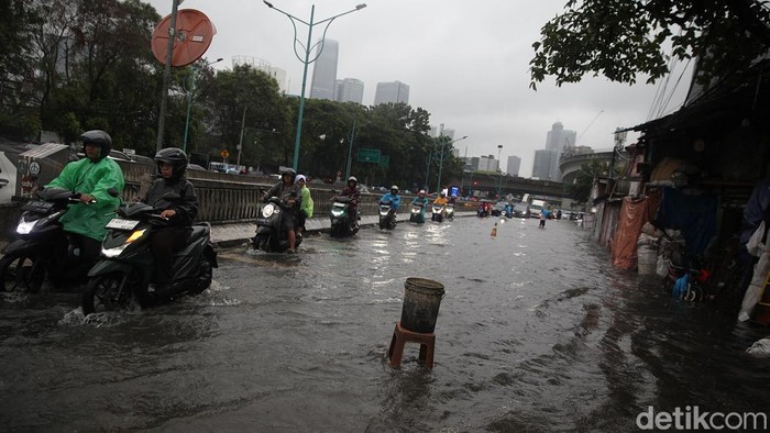 Pengendara menerobos genangan air di Jl Terusan Rasuna Said, Mampang Prapatan, Jakarta Selatan, Selasa (18/11/2025). Hujan deras sejak pukul 11.00 WIB membuat sejumlah ruas jalan tergenang hingga 50 cm.