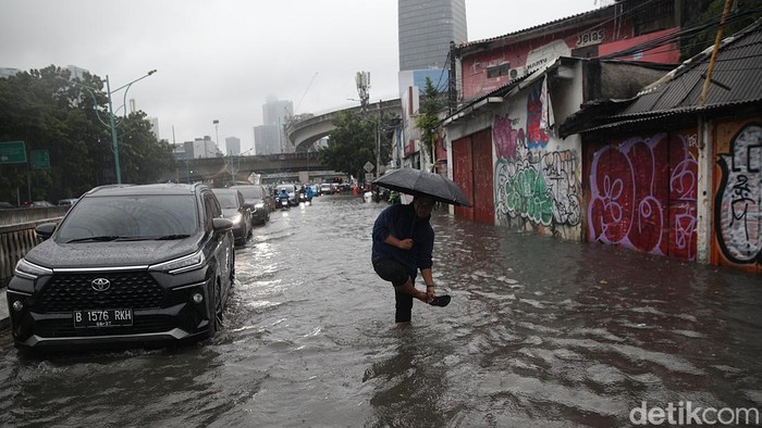 Pengendara menerobos genangan air di Jl Terusan Rasuna Said, Mampang Prapatan, Jakarta Selatan, Selasa (18/11/2025). Hujan deras sejak pukul 11.00 WIB membuat sejumlah ruas jalan tergenang hingga 50 cm.