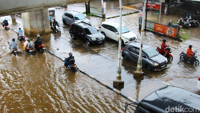 Warga mendorong motornya menembus genangan air di Jalan Ciledug Raya, Jakarta Selatan, Selasa (18/11/2025). Genangan tersebut berasal dari hujan deras dan meluapnya Kali Uwangan dan menggenangi jalan Ciledug Raya sekitar 60 sentimeter.