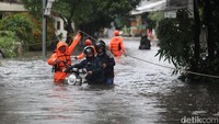 Warga menuntun motor menerobos banjir di Jl Pondok Karya, Mampang Prapatan, Terusan Rasuna Said, Pela Mampang, Jakarta Selatan, Selasa (18/11/2025).