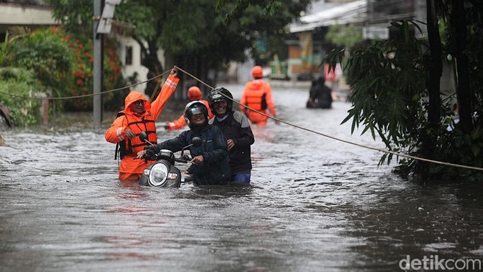Petugas mengevakuasi warga menggunakan perahu karet dan menerobos banjir di Jl Pondok Karya, Mampang Prapatan, Terusan Rasuna Said, Pela Mampang, Jakarta Selatan, Selasa (18/11/2025). Hujan deras sejak pukul 11.00 WIB membuat aliran sungai meluber hingga ke jalan dan pemukiman.