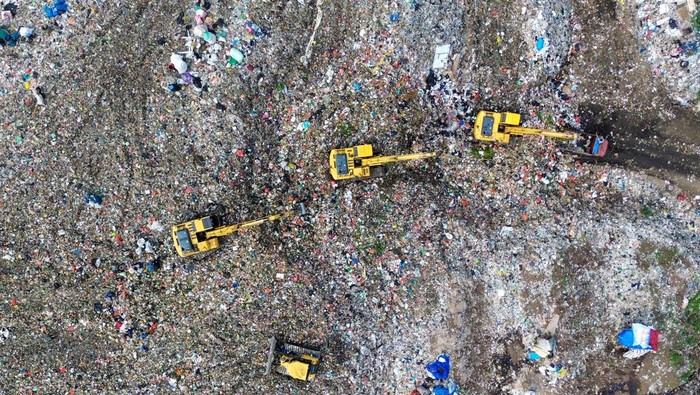 Foto udara alat berat meratakan sampah di Tempat Pembuangan Akhir (TPA) Sampah Griyo Mulyo Jabon, Sidoarjo, Jawa Timur, Selasa (18/11/2025). Menurut Dinas Lingkungan Hidup dan Kebersihan setempat, Volume sampah di Tempat Pembuangan Akhir (TPA) Jabon bertambah dari biasanya hanya 550 ton per hari kini meningkat sekitar 600 ton seiring masifnya normalisasi sungai yang membawa tambahan material ke lokasi pembuangan akhir saat musim hujan. ANTARA FOTO/Umarul Faruq/foc.