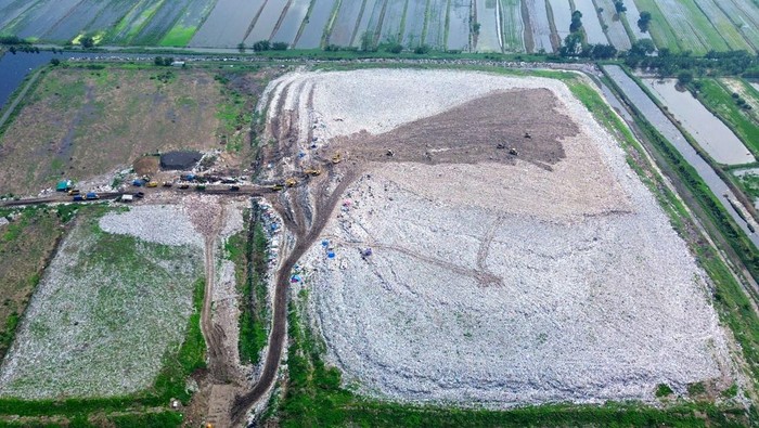 Foto udara alat berat meratakan sampah di Tempat Pembuangan Akhir (TPA) Sampah Griyo Mulyo Jabon, Sidoarjo, Jawa Timur, Selasa (18/11/2025). Menurut Dinas Lingkungan Hidup dan Kebersihan setempat, Volume sampah di Tempat Pembuangan Akhir (TPA) Jabon bertambah dari biasanya hanya 550 ton per hari kini meningkat sekitar 600 ton seiring masifnya normalisasi sungai yang membawa tambahan material ke lokasi pembuangan akhir saat musim hujan. ANTARA FOTO/Umarul Faruq/foc.