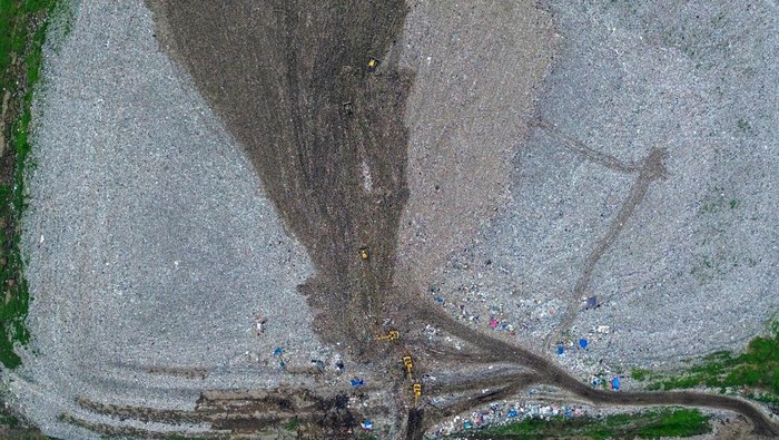 Foto udara alat berat meratakan sampah di Tempat Pembuangan Akhir (TPA) Sampah Griyo Mulyo Jabon, Sidoarjo, Jawa Timur, Selasa (18/11/2025). Menurut Dinas Lingkungan Hidup dan Kebersihan setempat, Volume sampah di Tempat Pembuangan Akhir (TPA) Jabon bertambah dari biasanya hanya 550 ton per hari kini meningkat sekitar 600 ton seiring masifnya normalisasi sungai yang membawa tambahan material ke lokasi pembuangan akhir saat musim hujan. ANTARA FOTO/Umarul Faruq/foc.