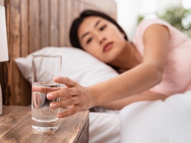 Healthy Liquid. Asian Lady Drinking Water From Glass Starting Day With Hydration Lying In Bed At Home. Selective Focus