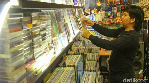 Seorang pekerja saat merapihkan piringan hitam yang dijual di Pasar Santa, Jakarta, Rabu (19/11/2025). Pecinta musik dan kaset jadul pastinya akan betah berlama-lama di Pasar Santa. Pasalnya, dalam Pasar ini terdapat satu area yang berisi berbagai macam toko yang menjual piringan hitam.
