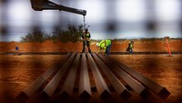 Pekerja berada di antara rangka baja tembok perbatasan yang tengah dipasang. Di berbagai titik seperti Santa Teresa di New Mexico, segmen baru terus dibangun dengan melibatkan alat berat, panel baja, dan teknologi pemantauan modern. REUTERS/Jose Luis Gonzalez