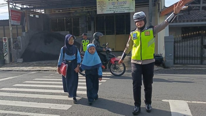 Petugas Satlantas Polres Batu membantu pejalan kaki menyebrang