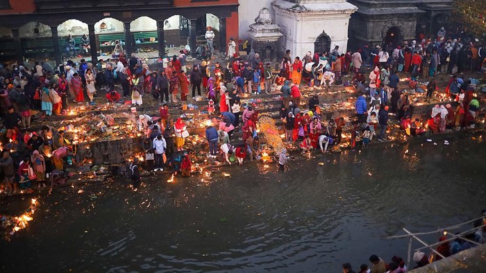 A Nepali Hindu devotee floats live oil-fed lamps in the sacred Bagmati River in Kathmandu, Nepal, on November 19, 2025, during Bala Chaturdashi, a festival to give salvation to departed souls. In remembrance of beloved ones, Nepali Hindu devotees offer oil-fed lamps into the Bagmati River flowing through the premises of Pashupatinath Temple in Kathmandu on the day of Bala Chaturdashi. The live lamps float on the river, which is believed to lighten the world of departed souls in their afterlife. Devotees remain awake throughout the night, camping on the edge of the Bagmati River facing the Pashupatinath Temple. Rituals for Bala Chaturdashi start from Marga Krishna Trayodashi, the 13th day of the waning moon in the month of Mangsir (8th month according to the Nepali calendar). Devotees who observe this ritual maintain strict fasting, with only one meal that day and abstain from garlic, onions, fish, eggs, and other food items that are said to be impure. In the evening, they reach the Pashupatinath temple or shrines dedicated to Lord Shiva and chant hymns and prayers to Lord Shiva all night long. They light ''Akhanda Jyoti'' in the name of the deceased souls of their families. The next morning, Marga Krishna Chaturdashi, they take a holy bath and start their journey around the Pashupatinath temple premises, spreading seven kinds of grains along the way. The seven grains (also called Satbeej) include dhaan (rice), jau (barley), til (sesame), gahun (wheat), chana (chickpeas), makai (maize), and kaguno (foxtail millet). Devotees walk along Kailash-Suryaghat-Gaurighat-Aryaghat-Guhyeshwari-Mrigasthali-Bishworup-Kirateshwar-108 Shivalinga. (Photo by Subaas Shrestha/NurPhoto via Getty Images)