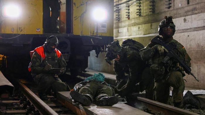 Stasiun metro Berlin yang biasanya dipenuhi para komuter berubah drastis menjadi arena latihan tempur pada Selasa pagi waktu setempat. Suara langkah sepatu bot, komando tegas, hingga simulasi tembakan menggema di lorong-lorong bawah tanah ketika tentara Jerman menggelar latihan penyerbuan dan evakuasi skala besar. REUTERS/Christian Mang
