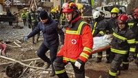 Petugas melakukan evakuasi terhadap korban di lokasi gedung apartemen yang terkena serangan rudal Rusia di Ternopil, Ukraina. REUTERS/STATE EMERGENCY SERVICE OF UKRAI
