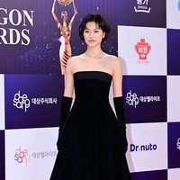 Mantan personel grup KPop I.O.I dan Weki Meki, Kim Doyeon memilih gaya old Hollywod glam yang klasik. Tampil memakai mini dres hitam, lengkap dengan stocking dan long gloves. Ia tak kuasa menahan air mata saat diumumkan sebagai Best New Actress. Foto: dok. Xports News