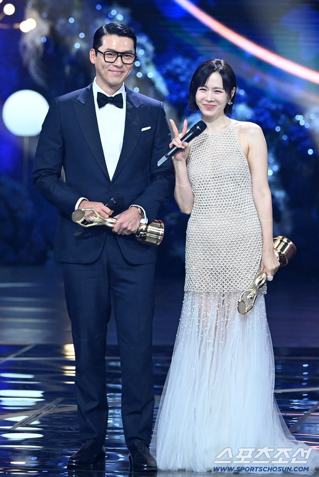 Malam itu, Hyun Bin tampil menawan dalam balutan tuxedo hitam, kacamata, dan dasi kupu-kupu. Sementara Son Ye Jin anggun dengan potongan rambut bob, memakai gaun semi transparan. Foto: dok. Twitter @sonyejinpics