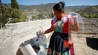 Perempuan Zapotec memantau masakan yang dimasak perlahan di panci surya di atap rumahnya. Ia telah menggunakan energi matahari selama hampir lima tahun demi menekan biaya dan menjaga kesehatan keluarga. REUTERS/Jorge Luis Plata