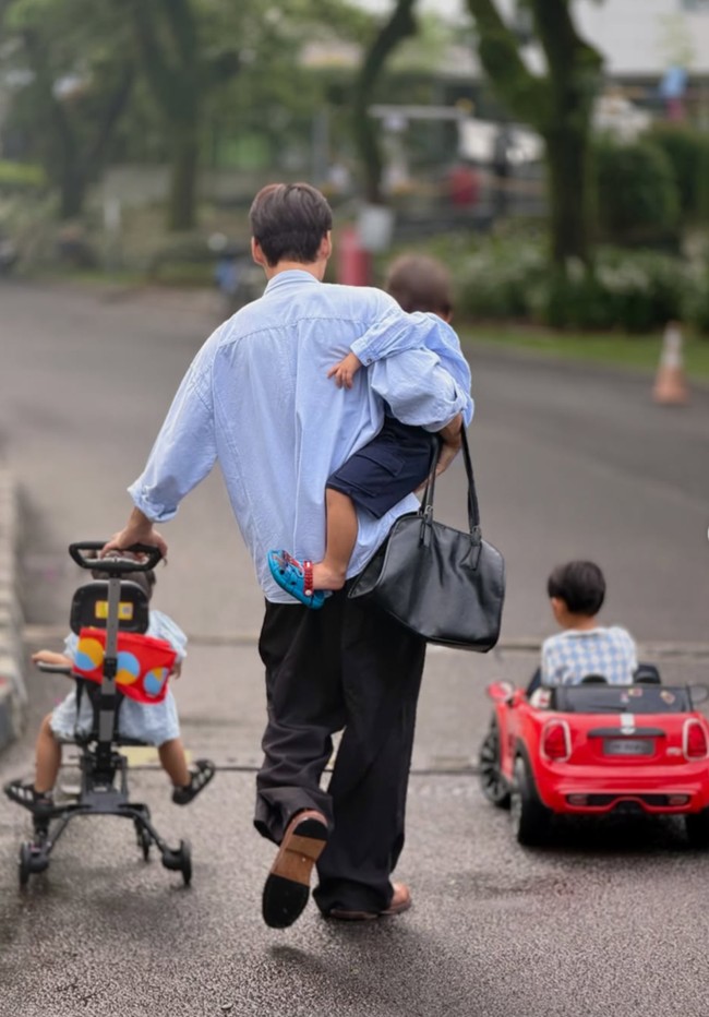 Banyak netizen yang memuji gaya bapakable Daehoon. Dalam foto terlihat ia bisa menggendong putranya sambil memegang tas, sementara tangan lainnya mendorong sepeda putri kecilnya. Foto: Instagram/@daehoon_na