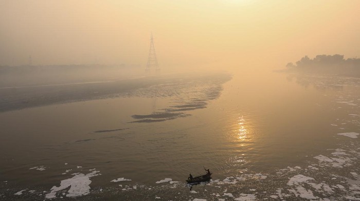 Kabut polusi kembali menyelimuti New Delhi pada Kamis (20/11/2025), menghadirkan suasana pagi yang suram di sepanjang Sungai Yamuna. Meski jarak pandang menurun drastis akibat lapisan kabut pekat yang tercampur polutan, sejumlah warga tetap melakukan aktivitas rutin mereka di bantaran sungai. REUTERS/Anushree Fadnavis