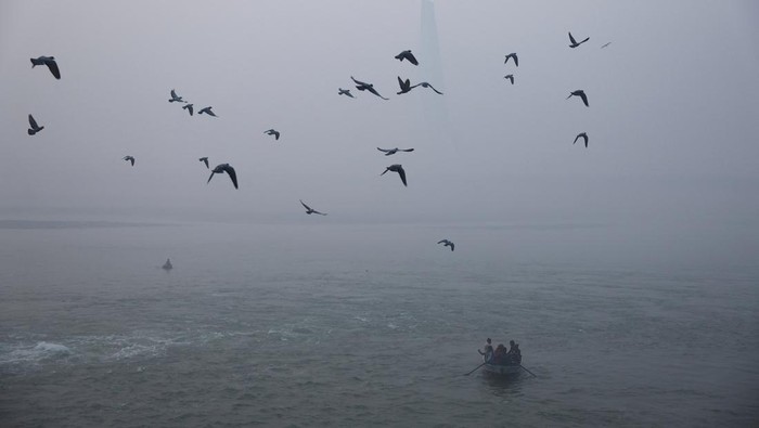Kabut polusi kembali menyelimuti New Delhi pada Kamis (20/11/2025), menghadirkan suasana pagi yang suram di sepanjang Sungai Yamuna. Meski jarak pandang menurun drastis akibat lapisan kabut pekat yang tercampur polutan, sejumlah warga tetap melakukan aktivitas rutin mereka di bantaran sungai. REUTERS/Anushree Fadnavis