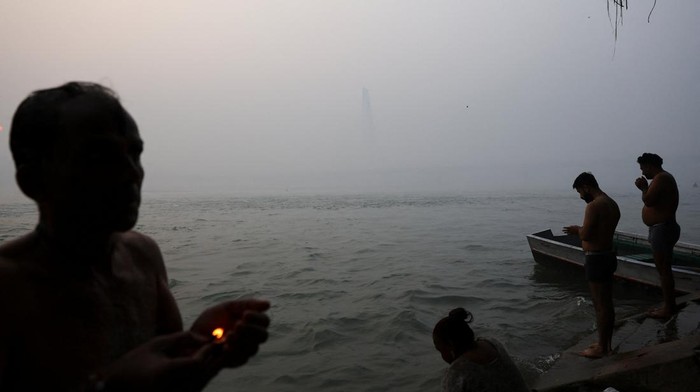 Kabut polusi kembali menyelimuti New Delhi pada Kamis (20/11/2025), menghadirkan suasana pagi yang suram di sepanjang Sungai Yamuna. Meski jarak pandang menurun drastis akibat lapisan kabut pekat yang tercampur polutan, sejumlah warga tetap melakukan aktivitas rutin mereka di bantaran sungai. REUTERS/Anushree Fadnavis