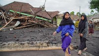Warga melintasi perkampungan yang terdampak erupsi Gunung Semeru di Desa Supiturang, Lumajang, Jawa Timur, Kamis (20/11/2025). ANTARA FOTO/Irfan Sumanjaya