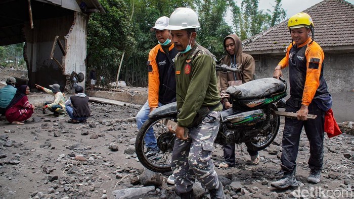Relawan membantu mengevakuasi barang milik warga di Desa Supiturang, Pronojiwo, Lumajang, Jawa Timur, Kamis (20/11/2025). Pemerintah provinsi Jawa Timur berkoordinasi dengan instansi terkait tengah menurunkan dua alat berat dan sejumlah tenaga penanggulangan bencana sebagai upaya percepatan penanganan pasca bencana erupsi Gunung Semeru. ANTARA FOTO/Irfan Sumanjaya/nz