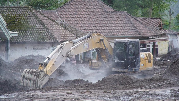Petugas membersihkan jalan dari timbunan material vulkanis di Desa Supiturang, Pronojiwo, Lumajang, Jawa Timur, Kamis (20/11/2025). Pemerintah provinsi Jawa Timur berkoordinasi dengan instansi terkait tengah menurunkan dua alat berat dan sejumlah tenaga penanggulangan bencana sebagai upaya percepatan penanganan pasca bencana erupsi Gunung Semeru. ANTARA FOTO/Irfan Sumanjaya/nz