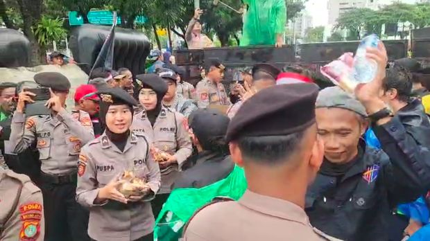 Personel Polda Metro Jaya mengamankan demo dari pelaku transportasi online. Polisi juga menunjukkan kepedulian dengan membagikan makan dan minuman ke massa. (dok Istimewa)