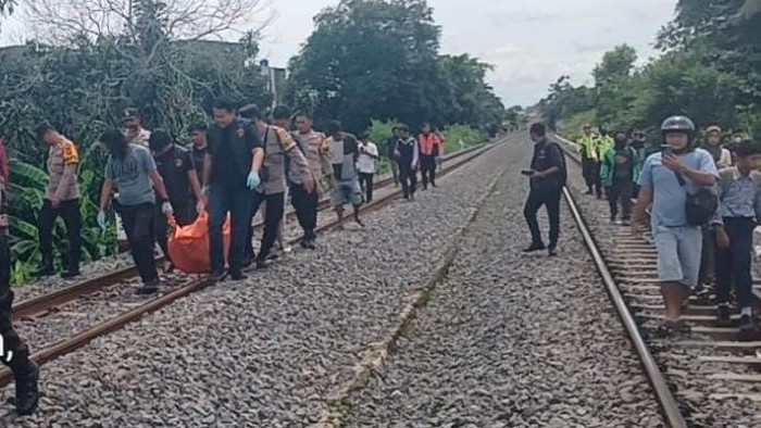Polisi saat mengevakuasi korban tewas tertabrak kereta api di Prabumulih.