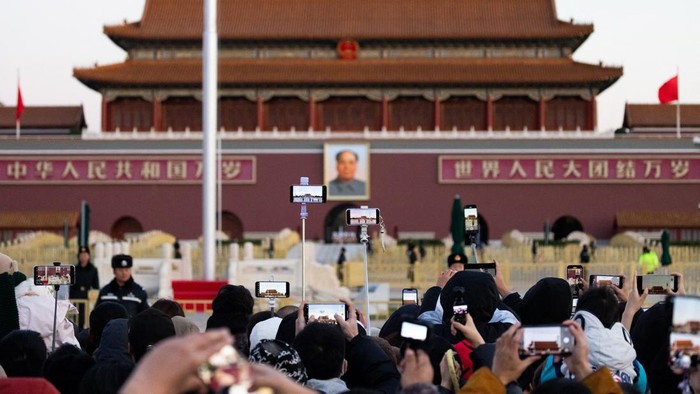Pagi masih gelap ketika ribuan warga Beijing mulai berdatangan ke Lapangan Tiananmen, Kamis (20/11/2025). Di tengah udara dingin musim gugur, mereka berjalan berkelompok, sebagian membawa kamera, sementara yang lain menggendong anak kecil agar tak ketinggalan momen bersejarah yang rutin berlangsung setiap hari: pengibaran bendera nasional Tiongkok. REUTERS/Maxim Shemetov