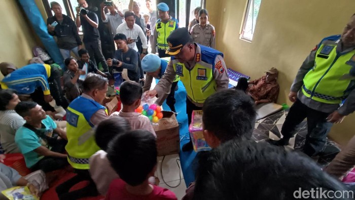 Anak pengungsi korban longsor mendapat mainan dari Kapolri di posko Balai Desa Cibeunying, Majenang, Cilacap, Jumat (21/11/2025).