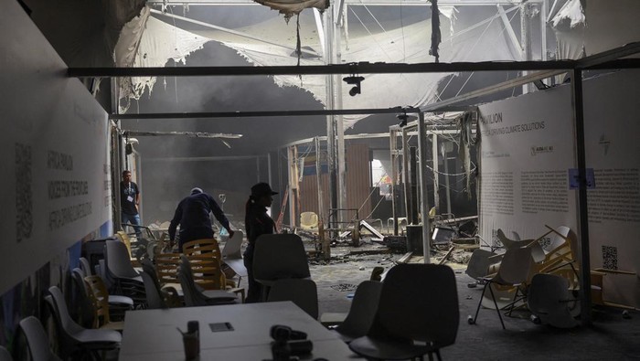 People walk inside a damaged structure following a fire alert during the UN Climate Change Conference (COP30), in Belem, Brazil, November 20, 2025. REUTERS/Adriano Machado