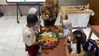 Saat mengajar, Nunuk menggunakan pendekatan pembelajaran unik dengan mengenalkan bangun datar melalui jajanan tradisional, seperti wajik berbentuk jajar genjang, kue berbentuk bola (lingkaran), jadah berbentuk persegi, hingga jajanan lain yang berbentuk segitiga. Foto: Fahri Zulfikar/detikcom