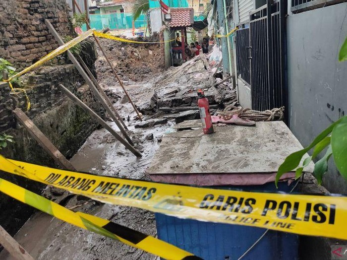 Garis polisi terpasang di sekeliling lokasi robohnya tembok pembatas sekolah SDN 01 dan SDN 02 serta SMPN 130 di Kelurahan Kota Bambu Utara, Palmerah, Jakbar, Jumat (21/11/2025). (ANTARA/Risky S)