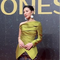 Istri Vidi Aldiano, Sheila Dara memilih memadukan one shoulder asimetri warna hijau terang dengan floral long skirt hitam. Ia melengkapi penampilannya dengan silver high heels. Foto: Instagram