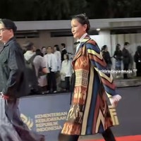 Penampilan Titi Rajo tak kalah jadi sorotan. Ia mengenakan outer etnik oversized yang dipadukan dengan celana panjang hitam serta high heels dan dasi kupu-kupu. Foto: Instagram