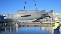 Seorang teknisi terlihat membantu menurunkan drone bawah laut Greyshark, sebuah autonomous underwater vehicle (AUV), ke perairan marina di Damp sebelum uji coba resmi di Laut Baltik. REUTERS/Fabian Bimmer