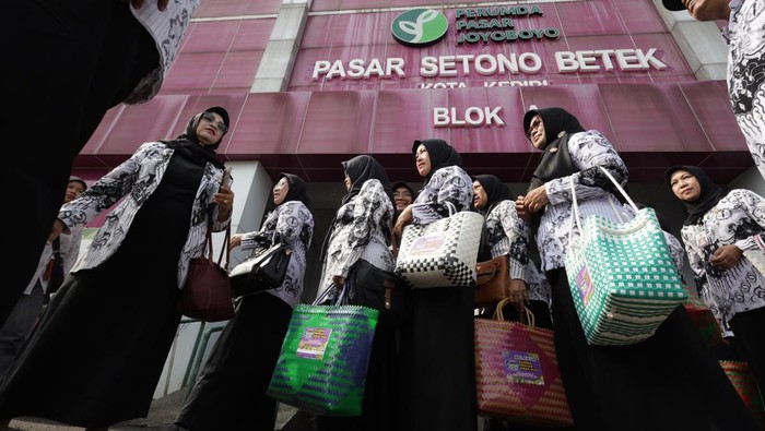 Sejumlah guru membeli makanan tradisional jenang saat aksi borong dagangan pasar di Pasar Bawang, Kota Kediri, Jawa Timur, Jumat (21/11/2025). Aksi serentak borong dagangan di sepuluh pasar tradisional dengan melibatkan sedikitnya1.500 guru se-Kota Kediri tersebut sebagai upaya menggerakkan ekonomi masyarakat kecil sekaligus memperingati HUT ke-80 Persatuan Guru Republik Indonesia (PGRI). ANTARA FOTO/Prasetia Fauzani