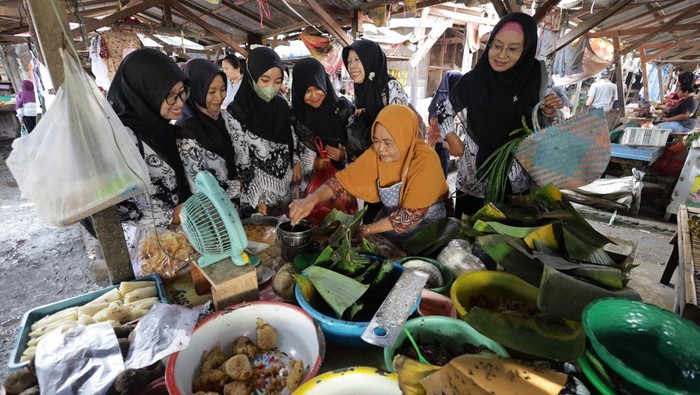 Sejumlah guru membeli makanan tradisional jenang saat aksi borong dagangan pasar di Pasar Bawang, Kota Kediri, Jawa Timur, Jumat (21/11/2025). Aksi serentak borong dagangan di sepuluh pasar tradisional dengan melibatkan sedikitnya1.500 guru se-Kota Kediri tersebut sebagai upaya menggerakkan ekonomi masyarakat kecil sekaligus memperingati HUT ke-80 Persatuan Guru Republik Indonesia (PGRI). ANTARA FOTO/Prasetia Fauzani