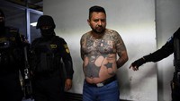 Pasukan khusus kepolisian Guatemala mengawal Ever Sinay, alias Cartoon, pemimpin geng 18th Street dan salah satu dari 20 buronan yang melarikan diri dari penjara Fraijanes II dan ditangkap kembali dengan bantuan Satuan Tugas Gabungan FBI Vulcan, di Istana Kehakiman di Guatemala City, Guatemala, Kamis (20/11/2025). REUTERS/Cristina Chiqiuin