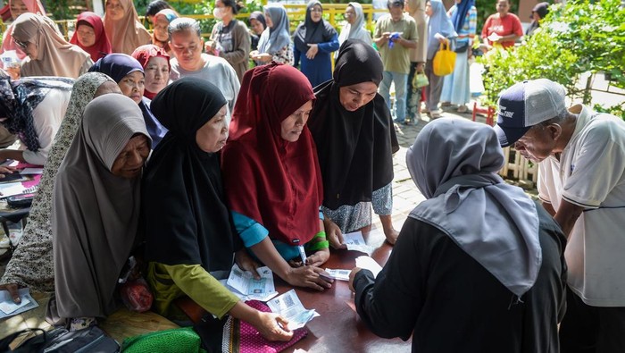 Petugas mendata warga penerima manfaat saat penyaluran bantuan pangan di kantor Kelurahan Cimone Jaya, Karawaci, Kota Tangerang, Banten, Jumat (21/11/2025). Pemerintah Kota Tangerang menyalurkan bantuan pangan dari Badan Pangan Nasional berupa 1.398.040 kilogram beras dan 279.608 liter minyak goreng untuk 69.902 penerima manfaat di 13 kecamatan wilayah Kota Tangerang. ANTARA FOTO/Putra M. Akbar