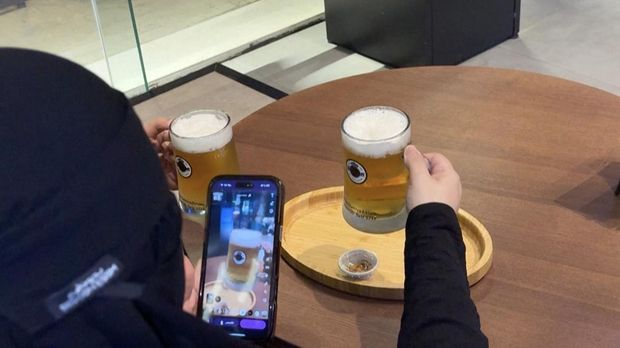 Sejumlah pelanggan berjubah putih hingga wanita berkerudung hitam menyesap bir tanpa alkohol tanpa khawatir mabuk di sebuah kedai di Riyadh, ibu kota Arab Saudi. (Tangkapan Layar Video AFP/Rania SANJAR)