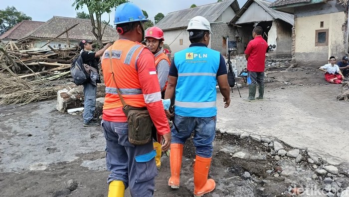 Sejumlah petugas PLN melakukan perbaikan jaringan listril yang diterjang awan panas Gunung Semeru.