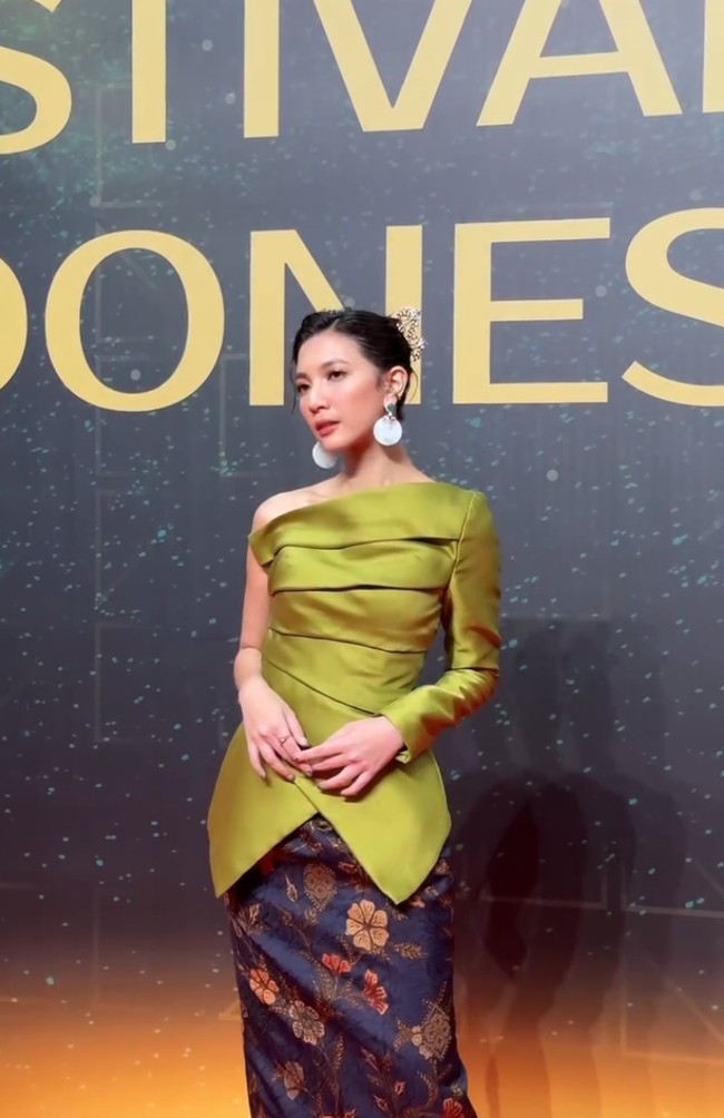 Warna hijau olive memberi nuansa segar dan modern, sekaligus kontras yang cantik dengan kain bawahan  bernuansa navy dengan motif bunga keemasan. Foto: Instagram/@hagaipakan