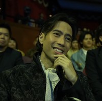 Vidi tampil mengenakan dalaman yang memiliki kerah putih beraksen renda. Ia memadukannya dengan outer bernuansa hitam dengan motif floral. Foto: YouTube Film Festival Indonesia