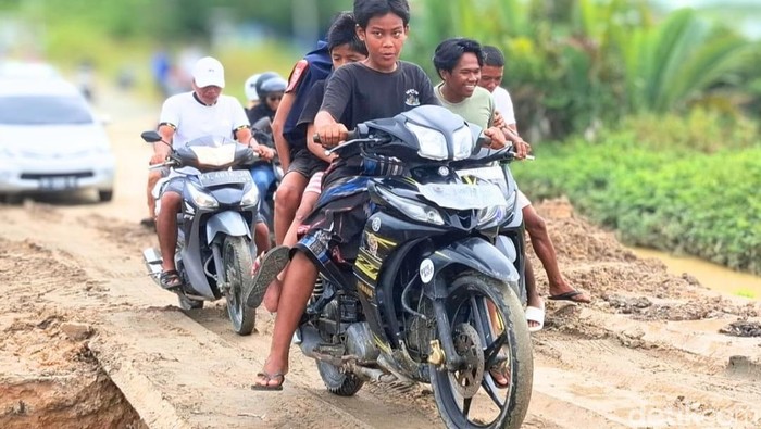 Warga berhati-hati saat melewati plat besi di jalan Binalatung. (Oktavian Balang/detikKalimantan)