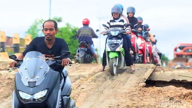 Warga berhati-hati saat melewati plat besi di jalan Binalatung. (Oktavian Balang/detikKalimantan)
