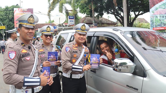Kasat Lantas Polres Magetan AKP Ade Andini saat memberikan bunga dan cokelat kepada pengendara.